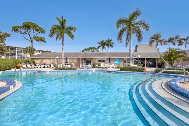 a view of a swimming pool with a garden and patio