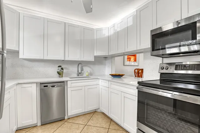 a kitchen with white cabinets and stainless steel appliances
