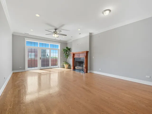 an empty room with fireplace fan and windows