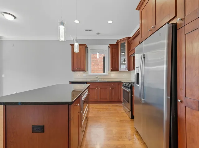 a kitchen with stainless steel appliances granite countertop a refrigerator a sink and a stove