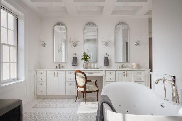 a spacious bathroom with double vanity sinks a mirror and a bathtub