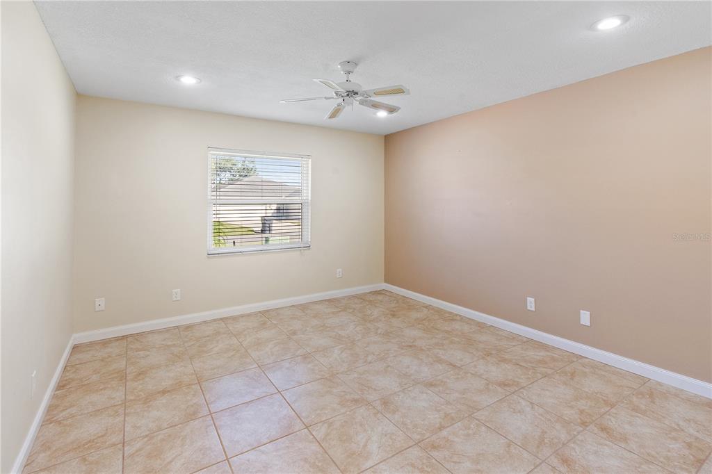 731 Canberra Road Winter Haven, FL 33884 - Photo 21 of 51 an empty room with a chandelier fan and windows