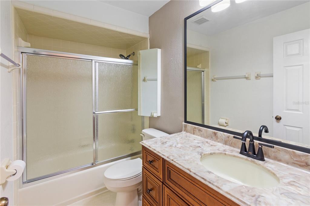 731 Canberra Road Winter Haven, FL 33884 - Photo 24 of 51 a bathroom with a granite countertop sink toilet and shower