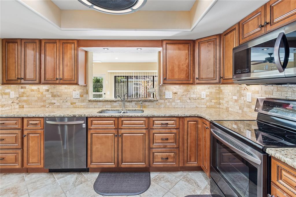 731 Canberra Road Winter Haven, FL 33884 - Photo 3 of 51 a kitchen with stainless steel appliances granite countertop a sink stove and cabinets