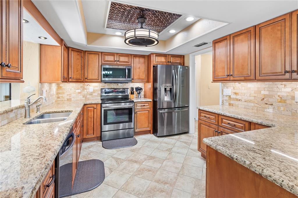 731 Canberra Road Winter Haven, FL 33884 - Photo 4 of 51 a kitchen with stainless steel appliances granite countertop a sink stove and refrigerator