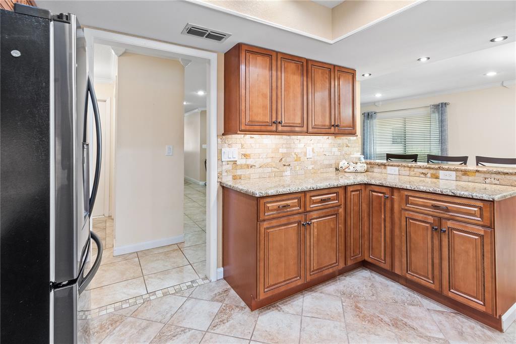 731 Canberra Road Winter Haven, FL 33884 - Photo 9 of 51 a kitchen with stainless steel appliances granite countertop a refrigerator and a sink