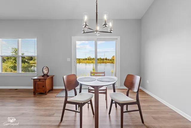 a dining room with furniture a chandelier and wooden floor