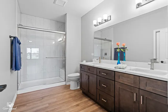 a bathroom with a double vanity sink mirror and shower