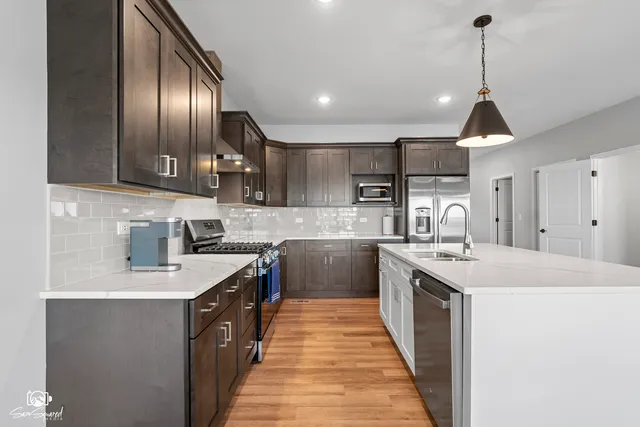 a kitchen with kitchen island granite countertop stainless steel appliances a sink stove top oven and cabinets