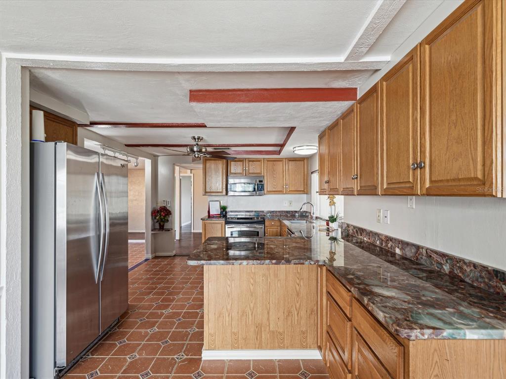 3730 Sail Drive New Port Richey, FL 34652 - Photo 12 of 50 a kitchen with stainless steel appliances granite countertop a refrigerator and a stove