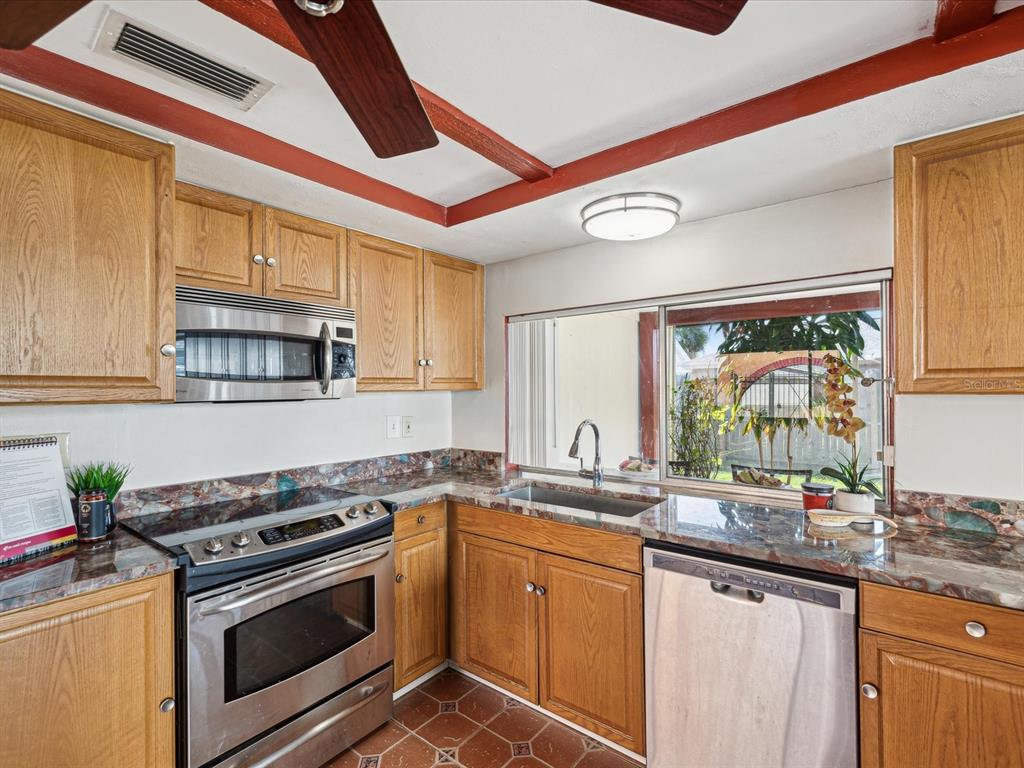 3730 Sail Drive New Port Richey, FL 34652 - Photo 9 of 50 a kitchen with stainless steel appliances granite countertop a sink and a stove