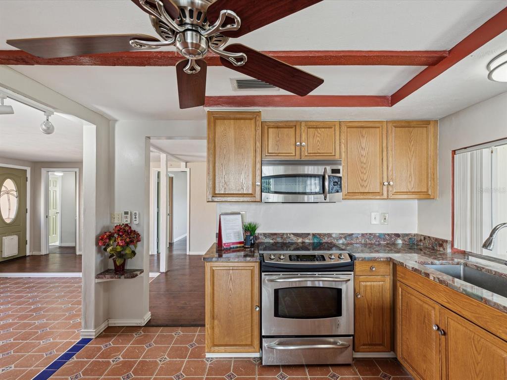 3730 Sail Drive New Port Richey, FL 34652 - Photo 10 of 50 a kitchen with stainless steel appliances granite countertop a stove a sink and a microwave