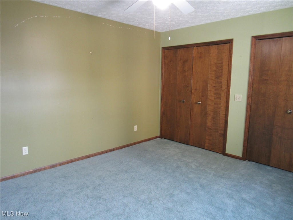 1120 Vincent Road Southeast North Canton, OH 44720 - Photo 38 of 50 Middle bedroom featuring new carpet, ceiling fan, double closets and a textured ceiling