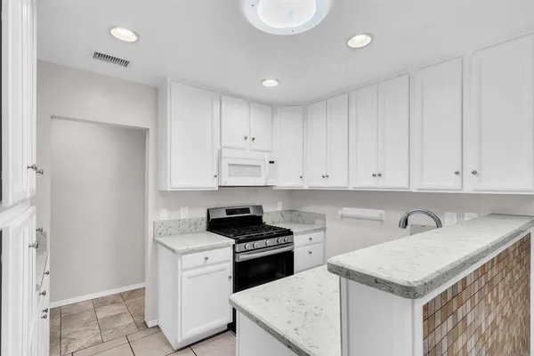 a kitchen with cabinets appliances a sink and a counter top space