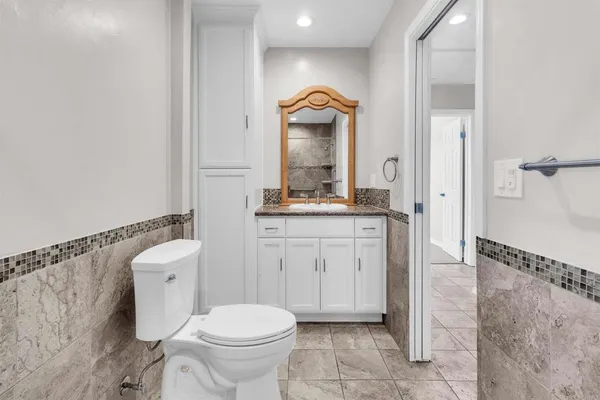 a bathroom with a toilet a sink and mirror