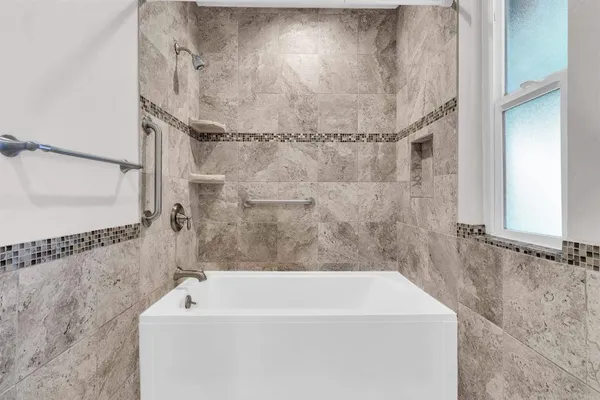 a bathroom with a bathtub and shower