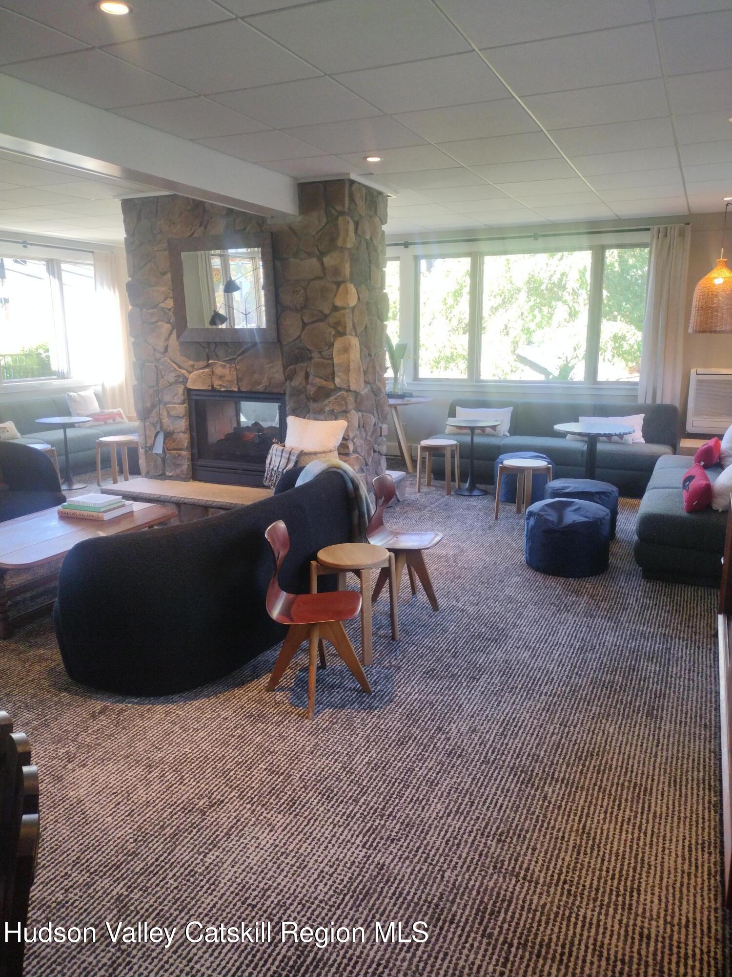 5220 Highway 23, Unit 126 Windham, NY 12496 - Photo 11 of 27 a living room with furniture a large window and a table