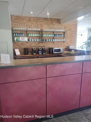 a view of a open kitchen with a sink and cabinets