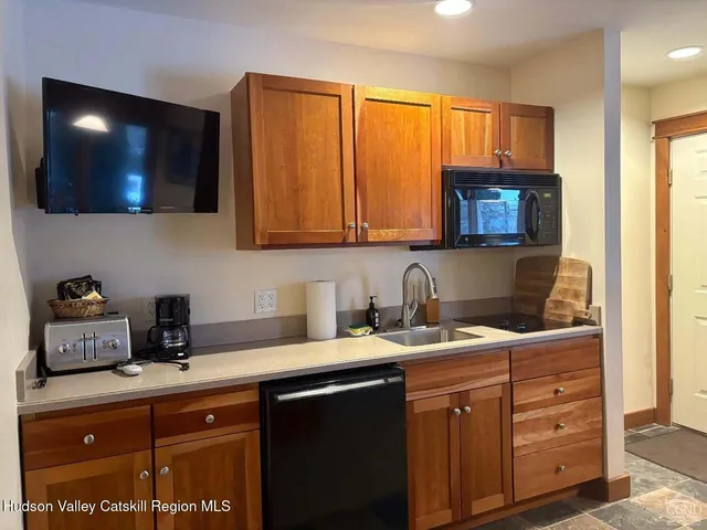 a kitchen with a sink a microwave and cabinets