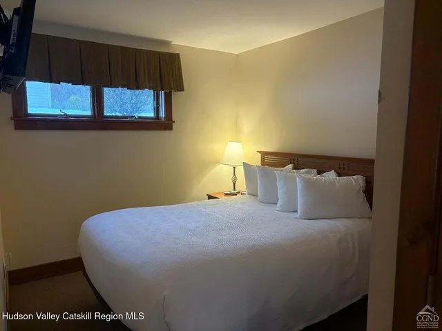 a bed sitting in a bedroom next to a window