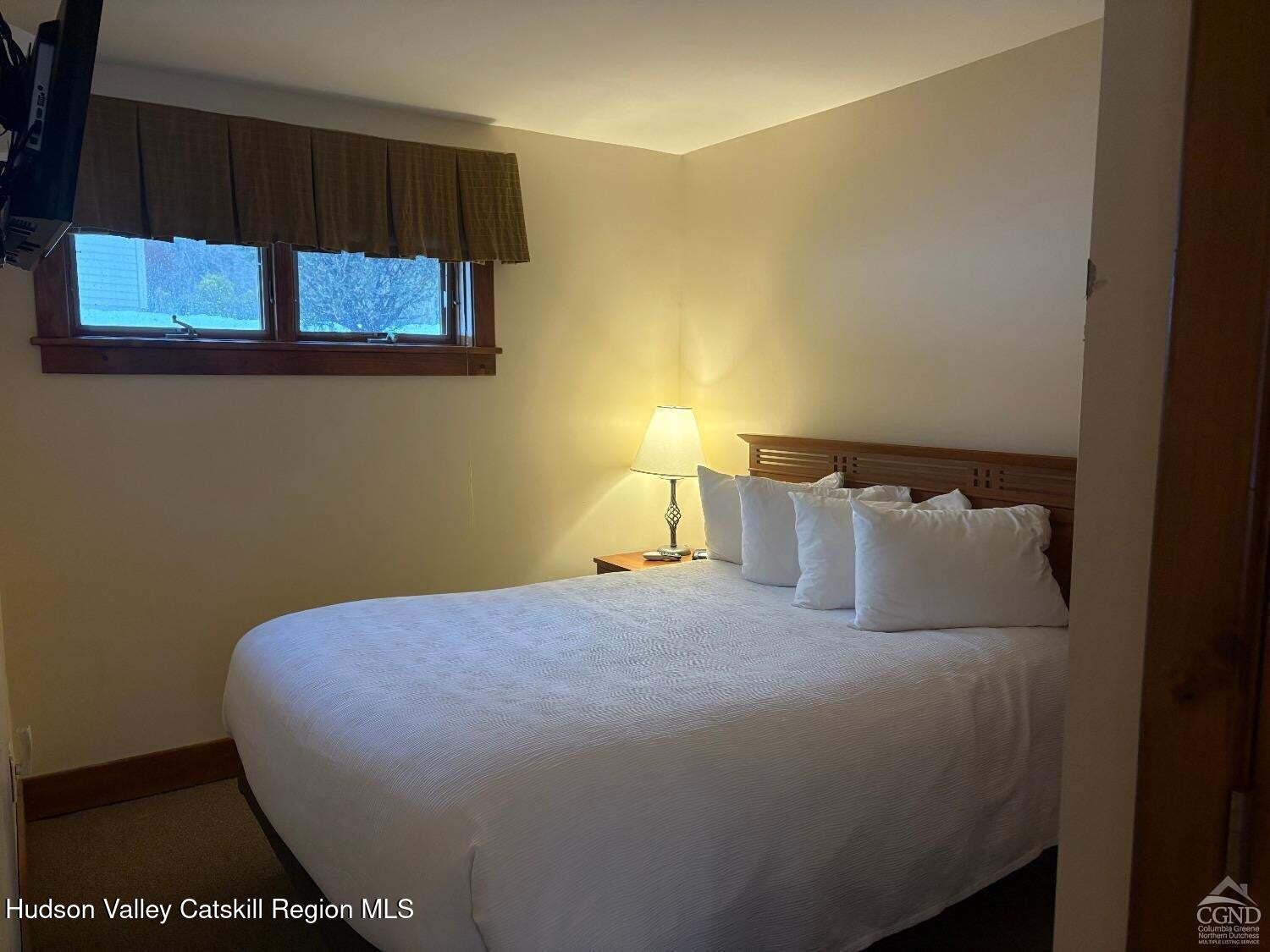 5220 Highway 23, Unit 126 Windham, NY 12496 - Photo 8 of 27 a bed sitting in a bedroom next to a window