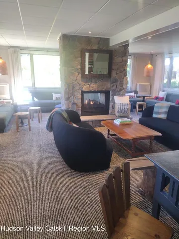 a living room with furniture a fireplace and a large window