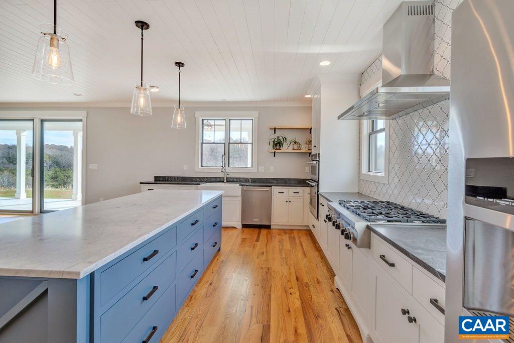 5797 Advance Mills Road Ruckersville, VA 22968 - Photo 11 of 50 a large kitchen with granite countertop a stove top oven a sink a dining table and chairs