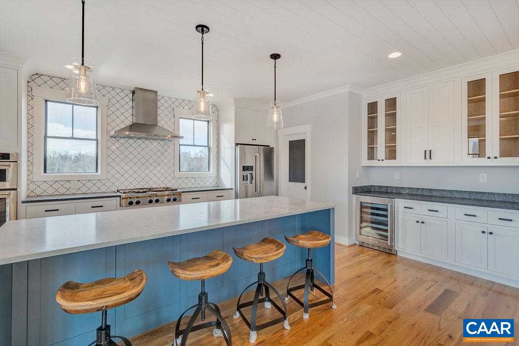 5797 Advance Mills Road Ruckersville, VA 22968 - Photo 15 of 50 a large kitchen with stainless steel appliances kitchen island granite countertop a table chairs in it and wooden floors