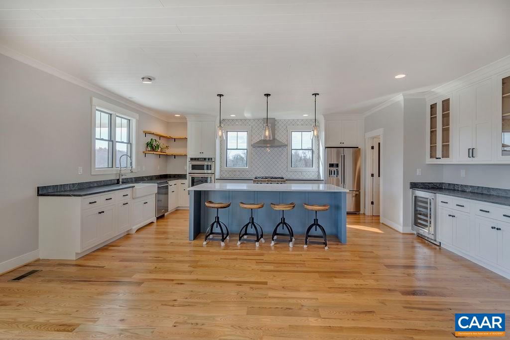 5797 Advance Mills Road Ruckersville, VA 22968 - Photo 9 of 50 a large kitchen with stainless steel appliances kitchen island granite countertop a stove a sink a refrigerator and white cabinets