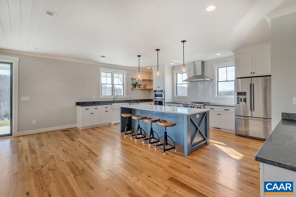 5797 Advance Mills Road Ruckersville, VA 22968 - Photo 10 of 50 a kitchen with stainless steel appliances granite countertop a table chairs refrigerator and sink