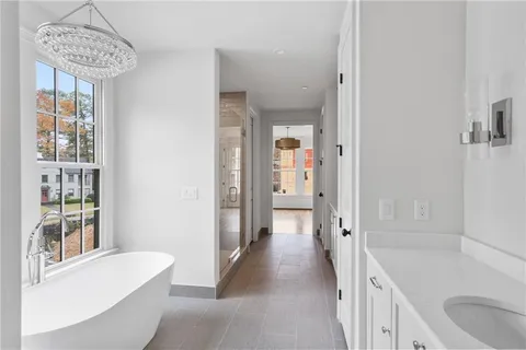 a bathroom with a tub a sink and a large mirror