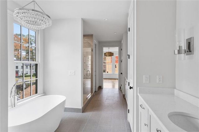 a bathroom with a tub a sink and a large mirror