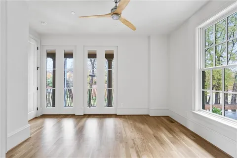 an empty room with wooden floor and windows
