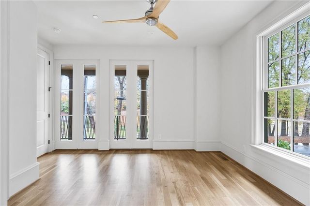 an empty room with wooden floor and windows