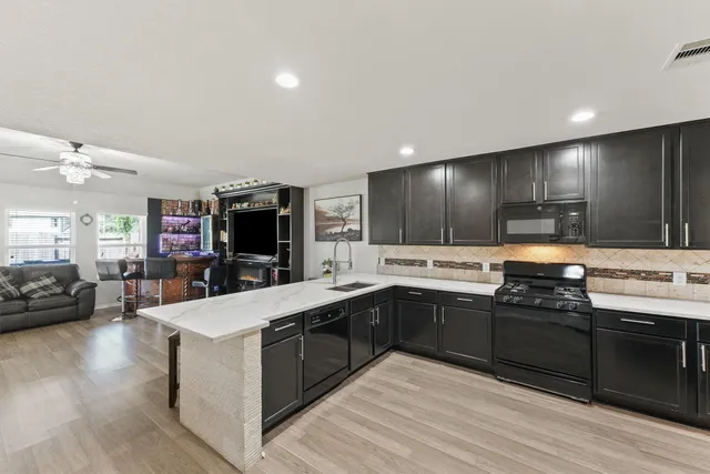 a large kitchen with stainless steel appliances kitchen island granite countertop a large counter top and sink