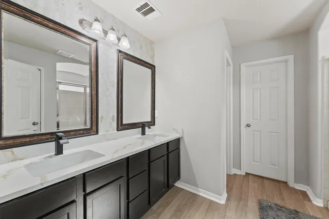 a bathroom with a double vanity sink and mirror