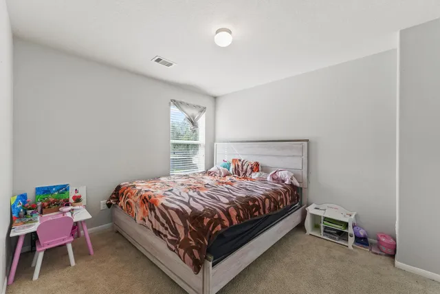 a bed sitting in a bedroom next to a window