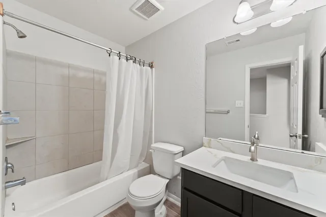 a bathroom with a sink a toilet tub and shower