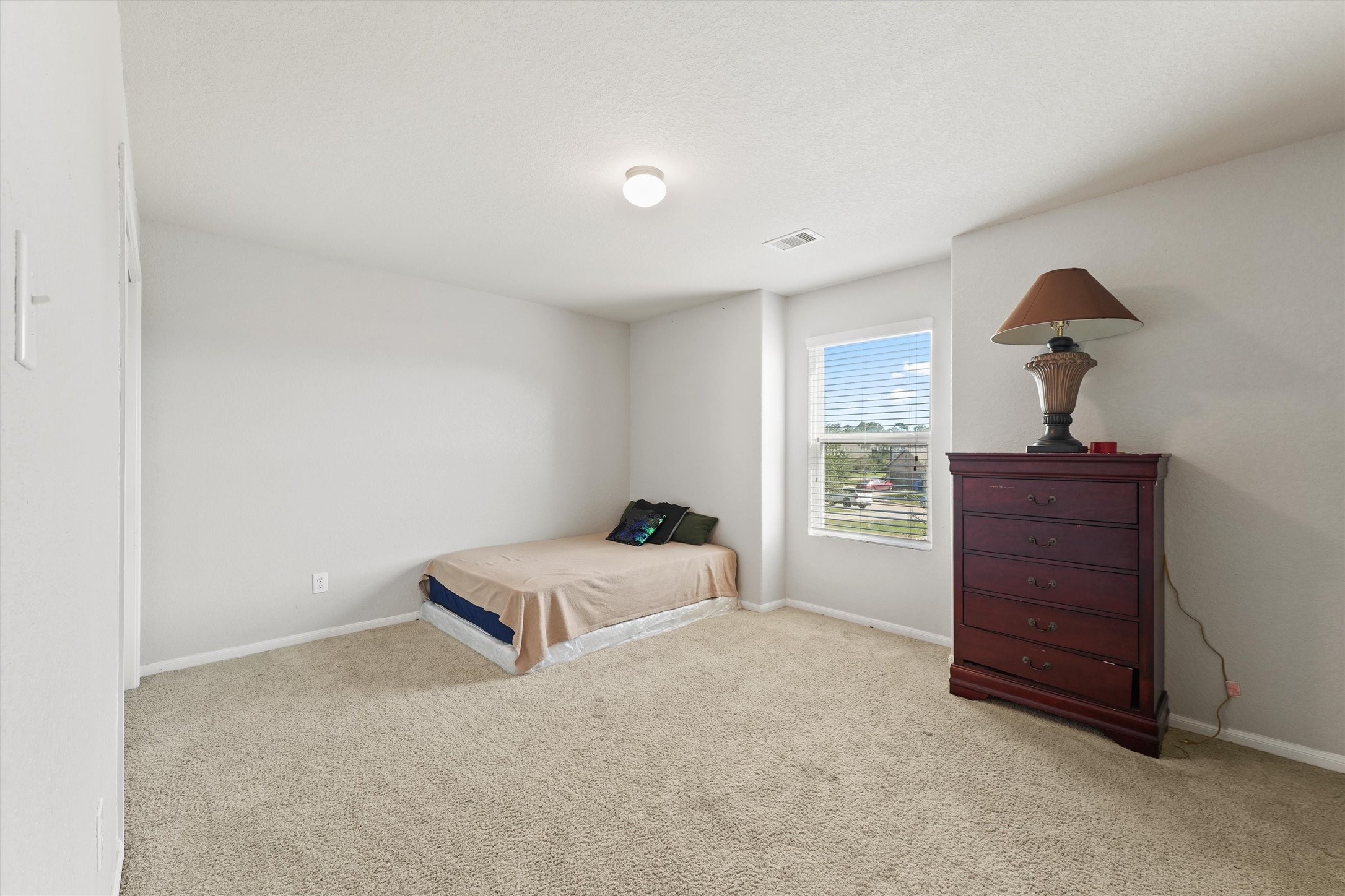 15307 Meandering Post Trail Houston, TX 77044 - Photo 19 of 25 a bedroom with a bed and a dresser