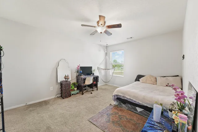 a bedroom with a bed a chandelier and a window