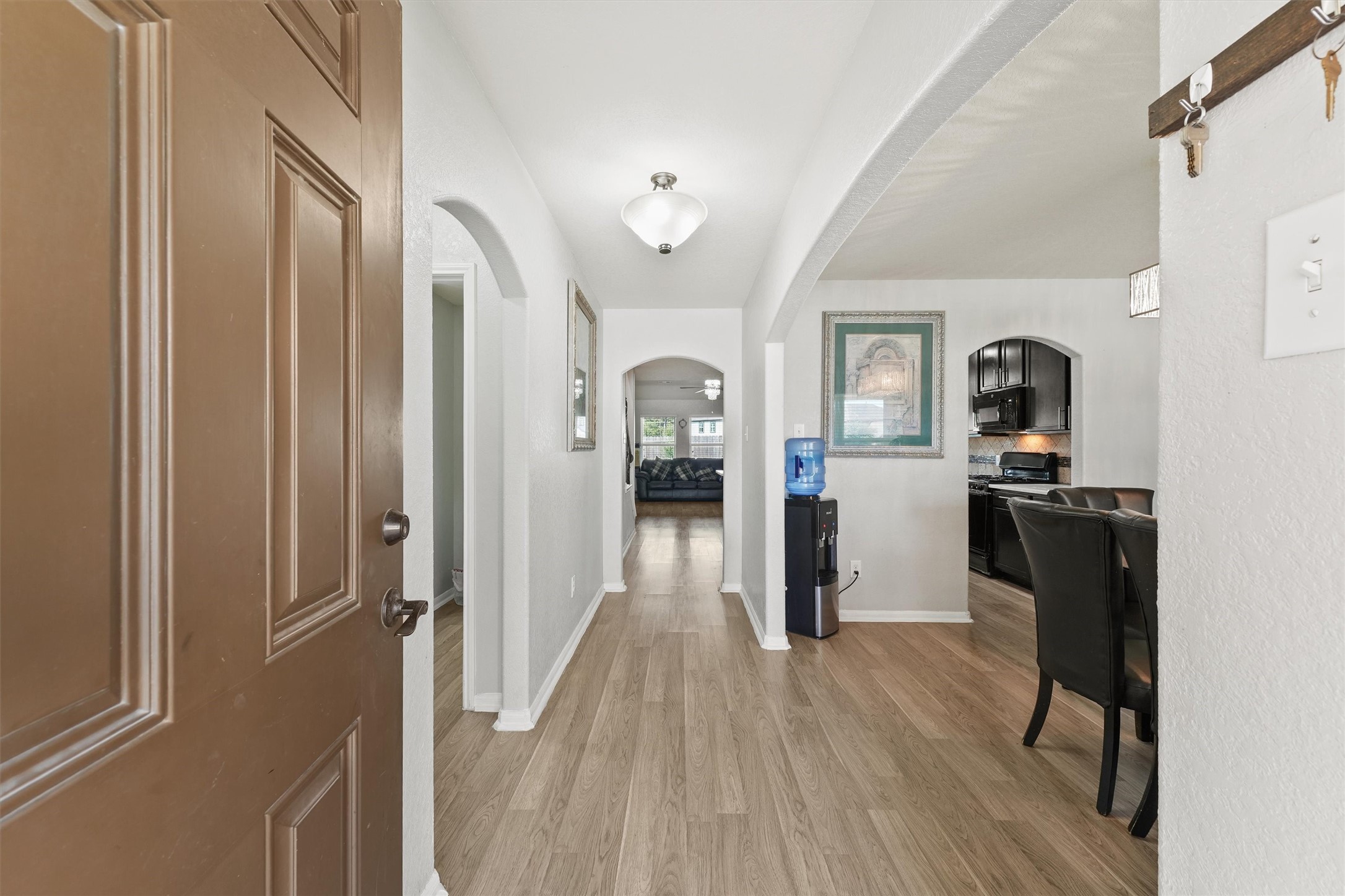 15307 Meandering Post Trail Houston, TX 77044 - Photo 5 of 25 a view of a hallway with wooden floor and furniture