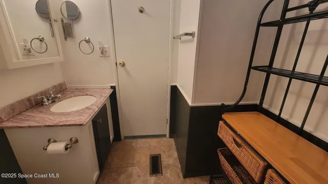a bathroom with a granite countertop sink toilet and mirror