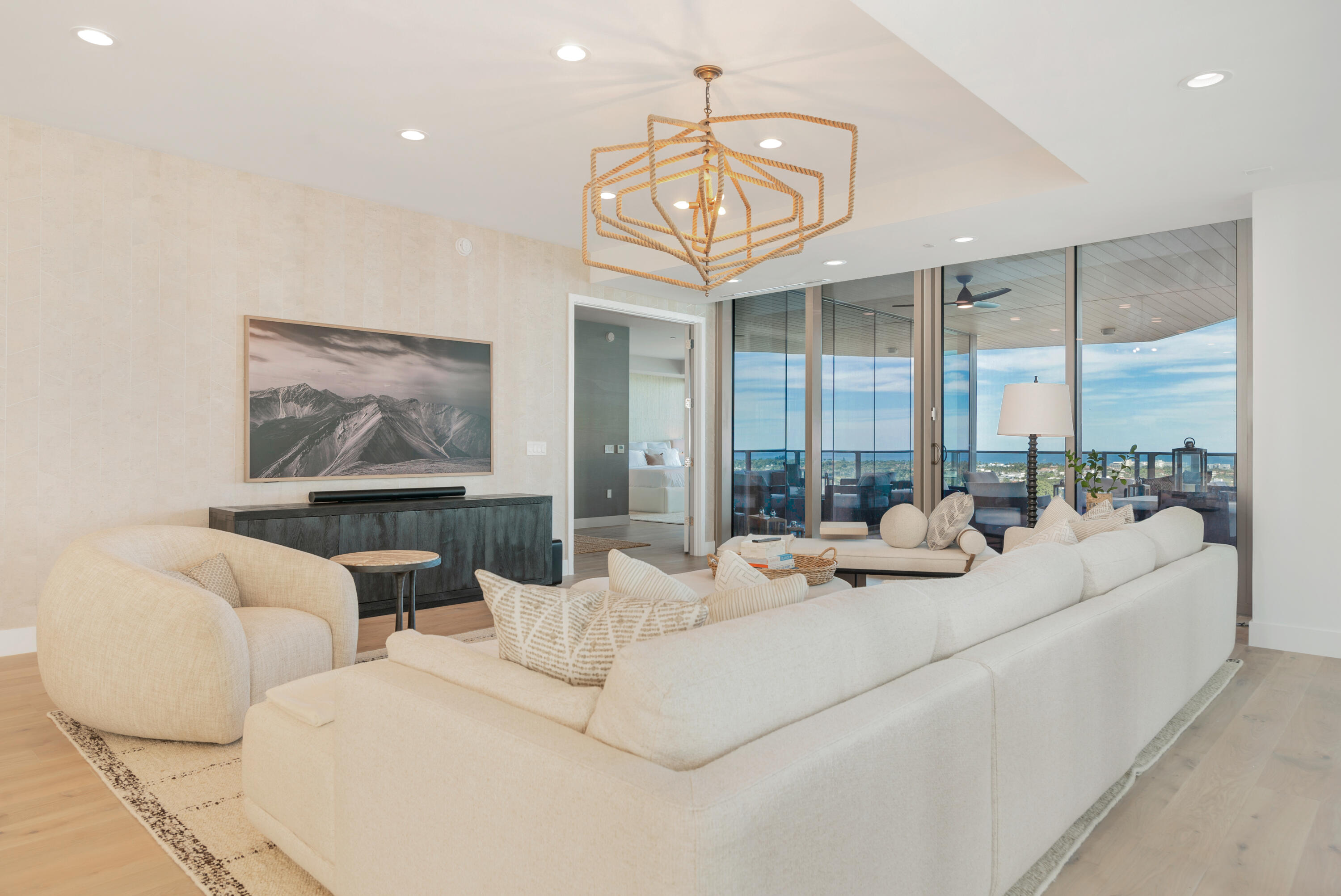 1333 South Flagler Drive, Unit 1202 West Palm Beach, FL 33401 - Photo 13 of 42 a living room with furniture a large window and a chandelier