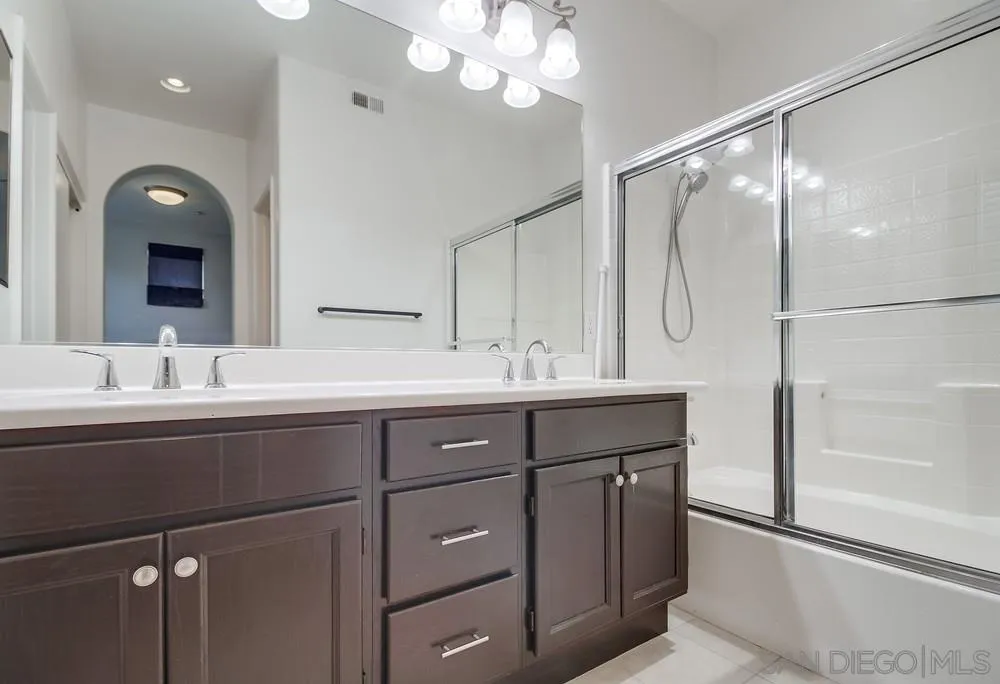 1298 Fools Gold Way, Unit 4 Chula Vista, CA 91913 - Photo 24 of 38 a bathroom with a double vanity sink mirror and shower