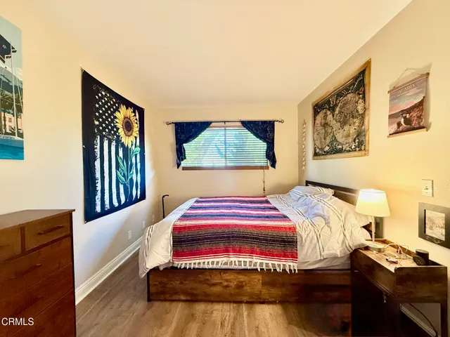 a bedroom with a bed and a painting on the wall