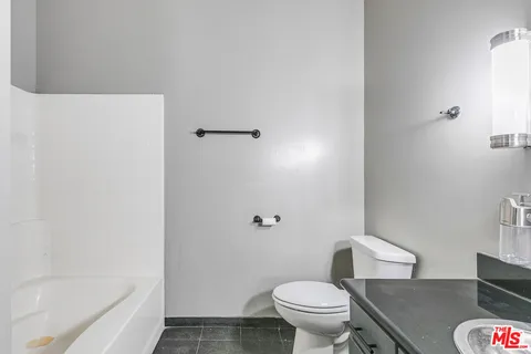 a white toilet sitting next to a bath tub