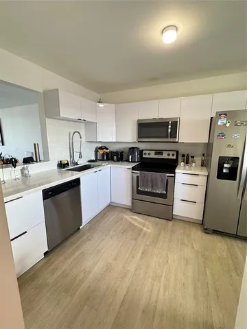 a kitchen with a sink a stove and cabinets