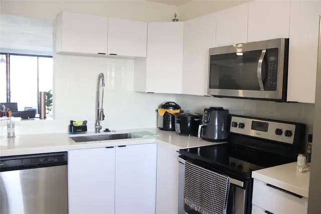 a kitchen with a sink a stove and a microwave