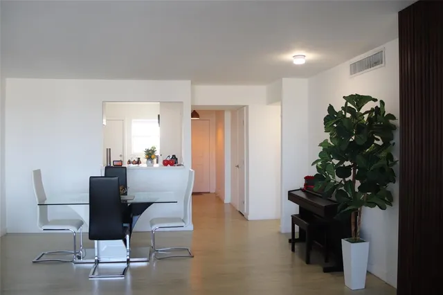 a dining room with furniture and a potted plant