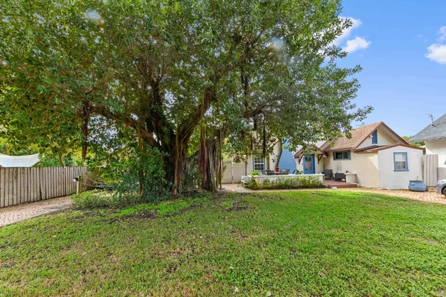 a front view of a house with a yard and trees